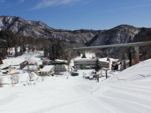 a ski resort in the snow with mountains in the background at Hotel Sunny Valley in Otari