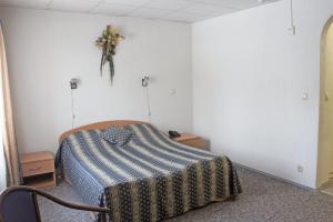 トリヤッチにあるHotel Altekのベッドルーム1室(ベッド1台付)、壁に飾られたフラワーアレンジメントが備わります。