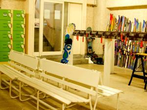 a group of benches in a room with snowboards at Hotel Sunny Valley in Otari