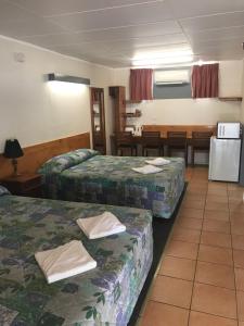 um quarto de hotel com duas camas e uma mesa em Blackall Coolibah Motel em Blackall