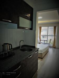 a kitchen with a sink and a bed in a room at Aydın Kent Suit in Aydın