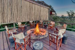 
a fire place with a picnic table and chairs at Mbali Mbali Soroi Serengeti Lodge in Banagi
