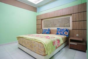 um quarto com uma cama e uma cabeceira em madeira em Hotel Bandung Permai em Bandung