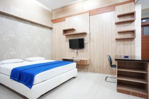 una camera con letto, scrivania e TV di Hotel Bandung Permai a Bandung