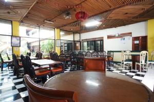 Hotel Bandung Permai في باندونغ: غرفة طعام مع طاولات وكراسي في مطعم
