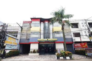 a building with a palm tree in front of it at Hotel Bandung Permai in Bandung +27 photos