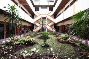 um pátio de um edifício com plantas e árvores em Hotel Bandung Permai em Bandung