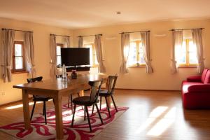 ein Wohnzimmer mit einem Holztisch und Stühlen in der Unterkunft Gasthaus Murauer in Simbach am Inn