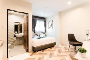 a bedroom with a bed and a bathroom with a sink at SJ Miracle Hotel in Hat Yai