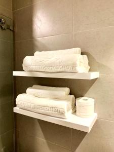 a pile of towels on shelves in a bathroom at Kim Oanh Orchids Hotel in Da Lat