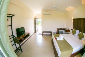 ein Schlafzimmer mit einem Bett und einem TV in einem Zimmer in der Unterkunft Royal Rock Sigiriya in Sigiriya