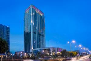 Crowne Plaza Hefei, an IHG Hotel في خفي: مبنى طويل مع أضواء على مدينة