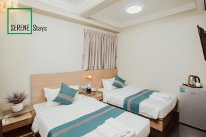 Ліжко або ліжка в номері SERENE Stays Hotel