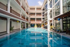 una gran piscina en un edificio con agua azul en Thanh Binh Central Hotel, en Hoi An