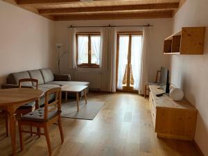 a living room with a couch and a table at Zum Dammerbauer in Straßlach-Dingharting
