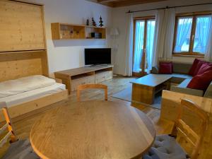 Straßlach-Dingharting的住宿－Zum Dammerbauer，客厅配有桌子和沙发