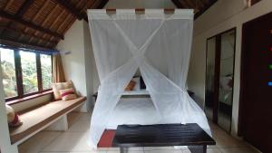 
a large white bed sitting in a room at Villa Pantulan Bali in Ubud
