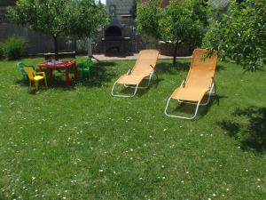 a group of chairs and a table in the grass at Katalin nyaraló in Balatonkeresztúr