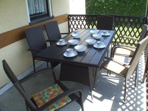 a wooden table with cups and saucers on it at Katalin nyaraló in Balatonkeresztúr +5 photos