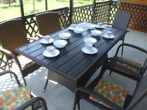 a wooden table with cups and saucers on it at Katalin nyaraló in Balatonkeresztúr