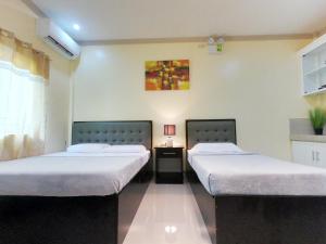 a room with two beds and a table in it at Mifaña Suites - Panglao Island in Dauis
