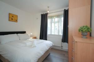Un dormitorio con una gran cama blanca y una ventana en Birmingham BHX-HS2 -NEC APARTMENT en Birmingham