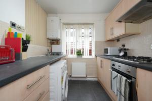 Il comprend une cuisine équipée d'un évier et d'une cuisinière. four supérieur dans l'établissement Birmingham BHX-HS2 -NEC APARTMENT, à Birmingham