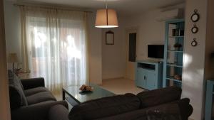 una sala de estar con un sofá y una mesa en Apartamento Julieta, en Sanlúcar de Barrameda