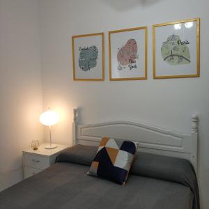 1 dormitorio con 1 cama y 3 cuadros en la pared en Apartamento Julieta, en Sanlúcar de Barrameda
