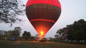um grande balão vermelho de ar quente num campo em Niduwari Lake Homestay em Dambulla