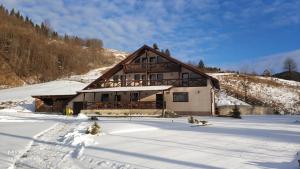 a large house in the snow with snow covered at Casa Roua Muntilor in Câmpulung Moldovenesc