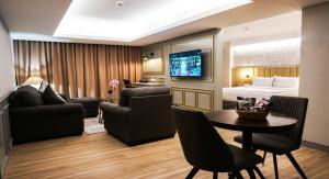 a living room with a room with a bed and a table at Barito Mansion in Jakarta