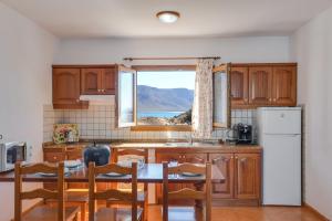 a kitchen with a table and chairs and a window at Apartamentos Flor Tres in Caleta de Sebo