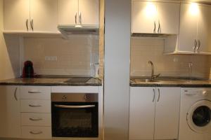 małą kuchnię z białymi szafkami i zlewem w obiekcie CENTRO ANTEQUERA Apartamento Calzada Centro w mieście Antequera +18 zdjęć