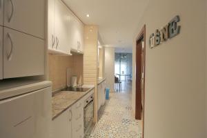 kuchnia z białymi szafkami i podłogą wyłożoną kafelkami w obiekcie CENTRO ANTEQUERA Apartamento Calzada Centro w mieście Antequera