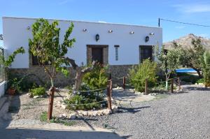 una casa con árboles y una valla delante de ella en Villa Garcia - Old Reformed Cortijo en Sorbas