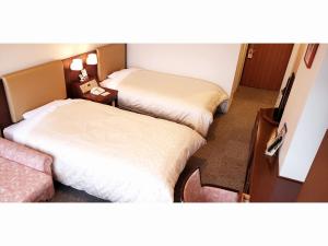 a hotel room with two beds and a table at Hotel Mielparque Kumamoto in Kumamoto +31 photos
