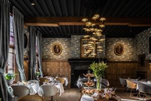 a restaurant with tables and chairs and a fireplace at Hotel De Orangerie by CW Hotel Collection - Small Luxury Hotels of the World in Bruges
