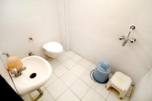 a white bathroom with a sink and a toilet at Hotel Gomatgiri in Aurangabad