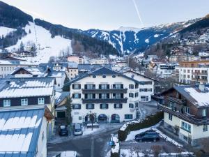 a group of buildings in a town with snow at Appartementhaus AURUM in Zell am See