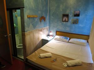 ein kleines Schlafzimmer mit einem Bett und einer Dusche in der Unterkunft Gabby's Bed & Breakfast in Dumaguete