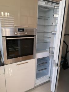 a kitchen with an empty refrigerator with an oven at Apartman Gaga 1 in Lukavica