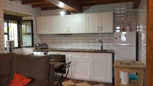 a kitchen with white cabinets and a white refrigerator at LA CASITA VERDE in Onís