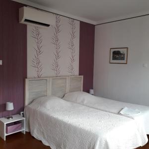 um quarto com uma cama branca e uma parede com um mural de plantas em Maison de malbrouck em Merschweiller