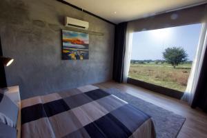 a bedroom with a bed and a large window at VILLA PADDY in Kampung Padang Masirat