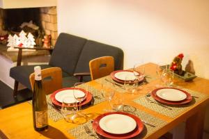 a wooden table with glasses and a bottle of wine at NEW - Les Carlinottes - Méribel - Au pied des pistes - Ski In-Ski Out in Méribel