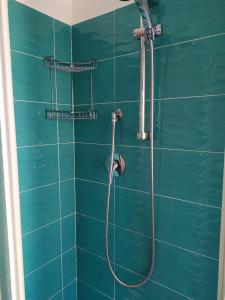 a green tiled shower with a hose in a bathroom at Confortevole appartamento a pochi passi dal mare in Cala Gonone +17 photos