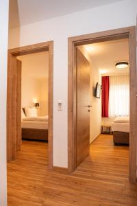 a door leading into a room with two beds at Appartementhaus AURUM in Zell am See