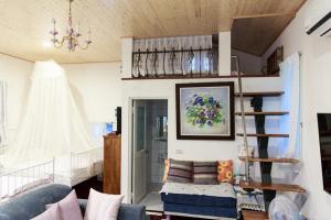 ein Wohnzimmer mit einem Kronleuchter und einer Wendeltreppe in der Unterkunft 伊莎貝爾花園民宿 in Wanqiao