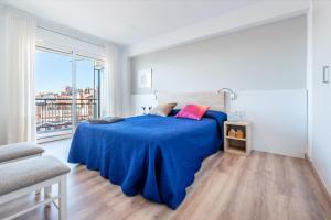a bedroom with a large bed with a blue blanket at Apartamentos Astoria in Tarragona
